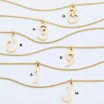 A floating Arabic initial 'S' (Seen) necklace in 18k gold-plated sterling silver, showing the unique sideways design of the letter integrated into the chain.