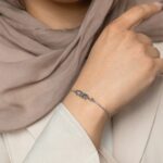 'Mama' Arabic calligraphy bracelet in 18k gold-plated sterling silver, worn on a woman's wrist, showing the delicate script.