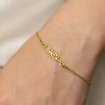 'Mama' Arabic calligraphy bracelet in 18k gold-plated sterling silver, worn on a woman's wrist, showing the delicate script.