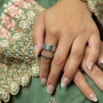 A woman's hand wearing the Cuban Link Chain Ring in 18k gold-plated sterling silver, showing the interlocking links wrapped around the finger.