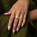 A woman's hand wearing the Cuban Link Chain Ring in 18k gold-plated sterling silver, showing the interlocking links wrapped around the finger.