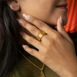 A woman's hand wearing the Cuban Link Chain Ring in 18k gold-plated sterling silver, showing the interlocking links wrapped around the finger.