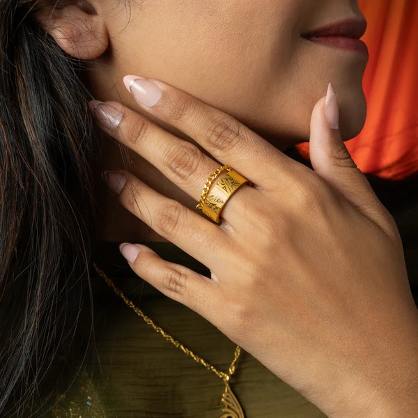 A woman's hand wearing the Cuban Link Chain Ring in 18k gold-plated sterling silver, showing the interlocking links wrapped around the finger.