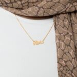 A personalized 'Jessica' name necklace in 18k gold-plated sterling silver, hanging from a delicate chain on a neutral background.