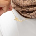 A personalized 'Jessica' name necklace in 18k gold-plated sterling silver, hanging from a delicate chain on a neutral background.