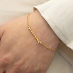 A Dainty Mama Script Bracelet in 18k gold-plated sterling silver, worn on a woman's wrist.