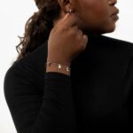 A delicate Celestial Moon and Star link bracelet in 18k gold-plated sterling silver, worn on a woman's wrist.