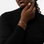 A delicate Celestial Moon and Star link bracelet in 18k gold-plated sterling silver, worn on a woman's wrist.