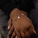 A delicate Celestial Moon and Star link bracelet in 18k gold-plated sterling silver, worn on a woman's wrist.