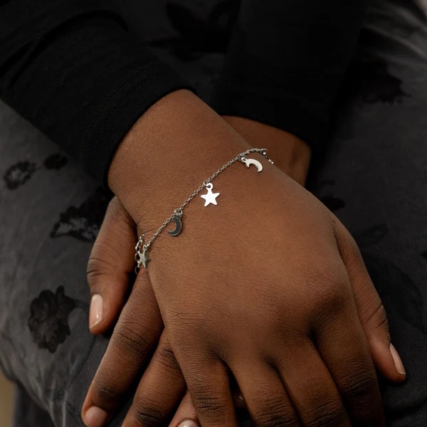 A delicate Celestial Moon and Star link bracelet in 18k gold-plated sterling silver, worn on a woman's wrist.