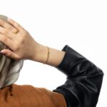 'Ukhti' Arabic calligraphy sister link bracelet in 18k gold-plated sterling silver, shown on a woman's wrist.