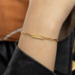 'Ukhti' Arabic calligraphy sister link bracelet in 18k gold-plated sterling silver, shown on a woman's wrist.