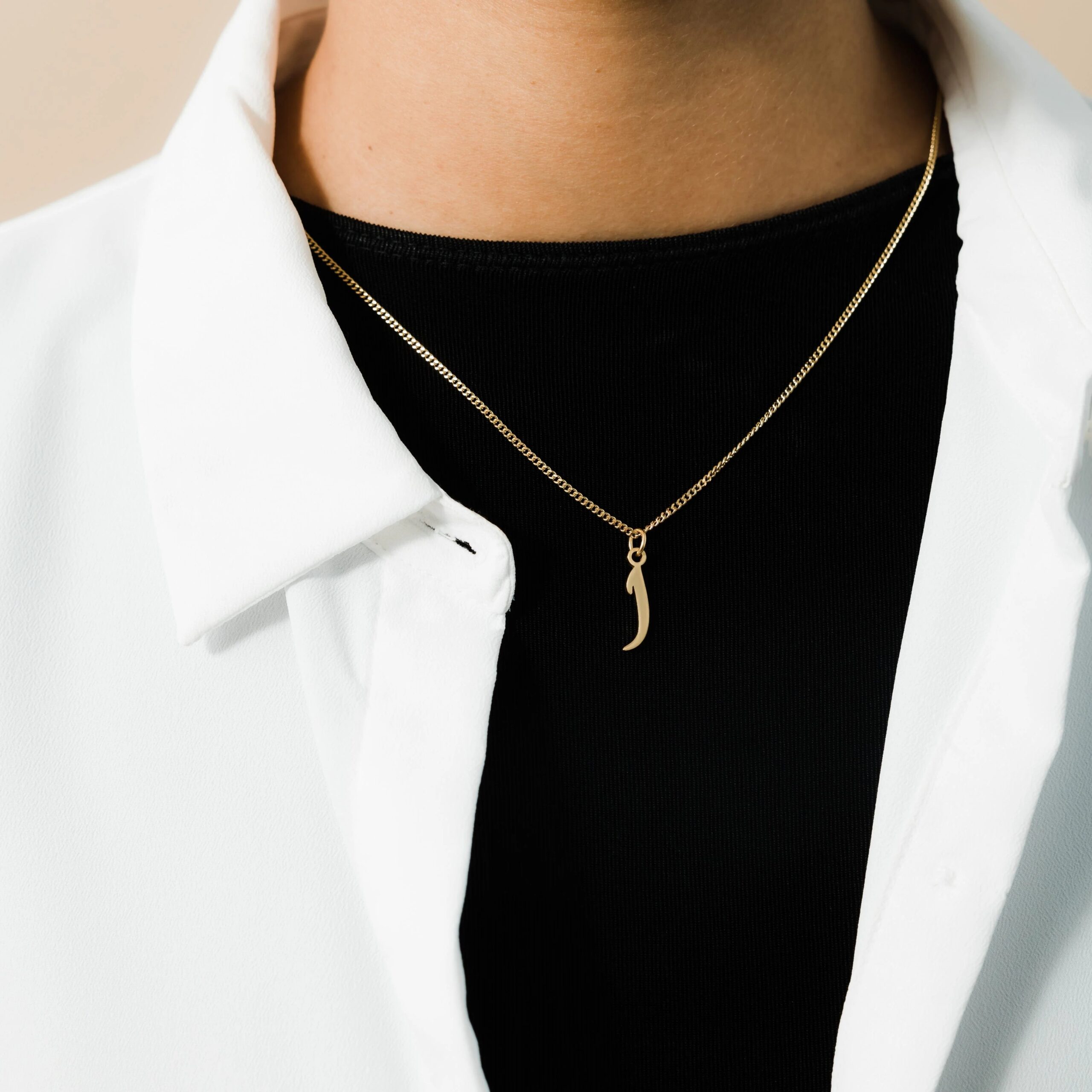 A floating Arabic initial 'S' (Seen) necklace in 18k gold-plated sterling silver, showing the unique sideways design of the letter integrated into the chain.