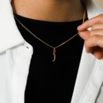 A floating Arabic initial 'S' (Seen) necklace in 18k gold-plated sterling silver, showing the unique sideways design of the letter integrated into the chain.