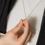 Arabic initial 'A' (Alif) letter necklace in 18k gold-plated sterling silver, hanging from a delicate chain on a plain background.