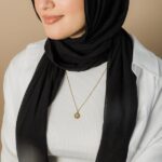 Arabic initial 'A' (Alif) letter necklace in 18k gold-plated sterling silver, hanging from a delicate chain on a plain background.