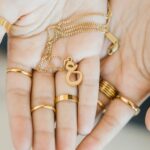 A floating Arabic initial 'S' (Seen) necklace in 18k gold-plated sterling silver, showing the unique sideways design of the letter integrated into the chain.