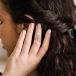 A delicate Olive Branch Peace Ring in 18k gold-plated sterling silver, worn on a finger to showcase the leaf design wrapping around it.