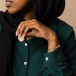 A wide Ayatul Kursi cuff bracelet in 18k rose gold-plated sterling silver, showing the intricate Arabic engraving of The Throne Verse on a woman's wrist.