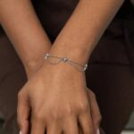 Guiding North Star Charm Bracelet in 18k gold-plated sterling silver, worn on a woman's wrist, highlighting the delicate starburst charms.