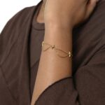 Guiding North Star Charm Bracelet in 18k gold-plated sterling silver, worn on a woman's wrist, highlighting the delicate starburst charms.