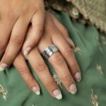 'Yusr' (Ease) Arabic calligraphy signet ring in 18k gold-plated sterling silver, worn on a finger to showcase the engraved face.