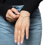 A woman's hand wearing the Twisted Rope Hand Chain in 18k gold-plated sterling silver, showing the delicate rope chain draping over the hand.