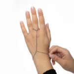 A woman's hand wearing the Twisted Rope Hand Chain in 18k gold-plated sterling silver, showing the delicate rope chain draping over the hand.