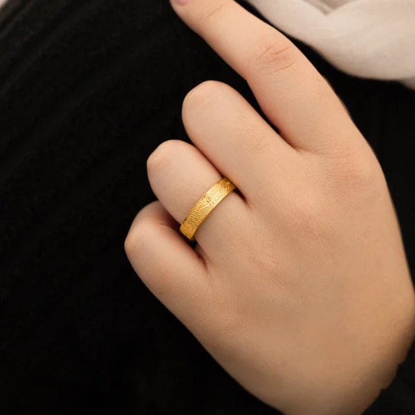 "With Hardship Comes Ease" engraved ring in 18k gold-plated sterling silver, worn on a finger to show the Arabic calligraphy band.