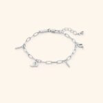 A woman's wrist wearing the Mama Charm Link Bracelet in 18k gold-plated sterling silver, showing the repeating engraved "Mama" medallions.