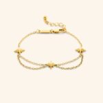 Guiding North Star Charm Bracelet in 18k gold-plated sterling silver, worn on a woman's wrist, highlighting the delicate starburst charms.