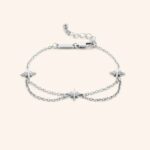 Guiding North Star Charm Bracelet in 18k gold-plated sterling silver, worn on a woman's wrist, highlighting the delicate starburst charms.