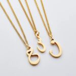 A floating Arabic initial 'S' (Seen) necklace in 18k gold-plated sterling silver, showing the unique sideways design of the letter integrated into the chain.