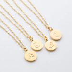Arabic initial 'A' (Alif) letter necklace in 18k gold-plated sterling silver, hanging from a delicate chain on a plain background.