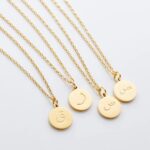 Arabic initial 'A' (Alif) letter necklace in 18k gold-plated sterling silver, hanging from a delicate chain on a plain background.