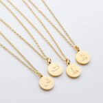 Arabic initial 'A' (Alif) letter necklace in 18k gold-plated sterling silver, hanging from a delicate chain on a plain background.