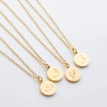 Arabic initial 'A' (Alif) letter necklace in 18k gold-plated sterling silver, hanging from a delicate chain on a plain background.