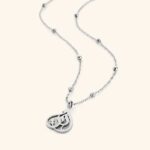 Model wearing the gold-plated sterling silver 'My Sister' Arabic calligraphy necklace (Ukhti) against a neutral background, showcasing its delicate chain and elegant script.