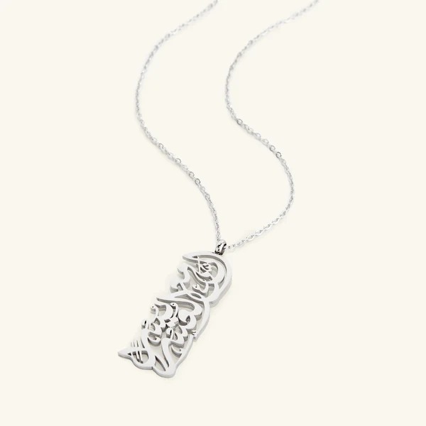 "With Hardship Comes Ease" medallion necklace in 18k gold-plated sterling silver, showcasing the intricate Arabic calligraphy engraving.