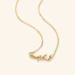 A 'Maktub' raised calligraphy necklace in 18k gold-plated sterling silver, showing the 3D effect of the Arabic script on the round medallion.