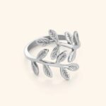 A delicate Olive Branch Peace Ring in 18k gold-plated sterling silver, worn on a finger to showcase the leaf design wrapping around it.