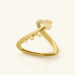 A woman's hand wearing the Kinetic Orbiting Sphere Ring in 18k gold-plated sterling silver, showing the moving bead on the elegant double band.
