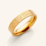"With Hardship Comes Ease" engraved ring in 18k gold-plated sterling silver, worn on a finger to show the Arabic calligraphy band.