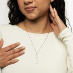 "With Hardship Comes Ease" medallion necklace in 18k gold-plated sterling silver, showcasing the intricate Arabic calligraphy engraving.