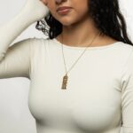 "With Hardship Comes Ease" medallion necklace in 18k gold-plated sterling silver, showcasing the intricate Arabic calligraphy engraving.
