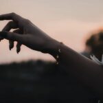 A delicate Celestial Moon and Star link bracelet in 18k gold-plated sterling silver, worn on a woman's wrist.