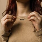 A vertical Shahada bar necklace in 18k gold-plated sterling silver, showing the clear Arabic calligraphy of the Islamic declaration of faith.